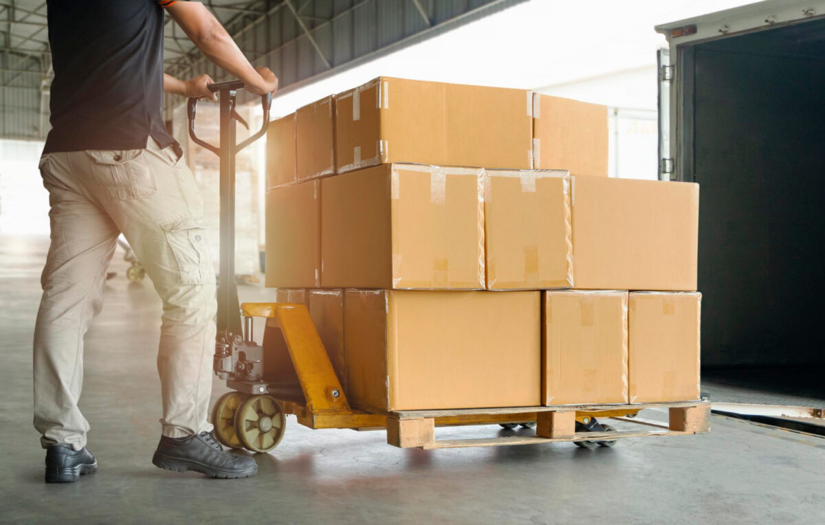 Des travailleurs déchargeant des boîtes d'emballage sur palette 