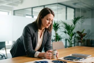 Femme professionnelle examinant des mugs et accessoires de bureau