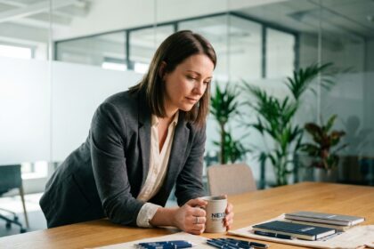 Femme professionnelle examinant des mugs et accessoires de bureau