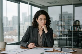 Femme en blazer regardant des rapports dans un bureau moderne