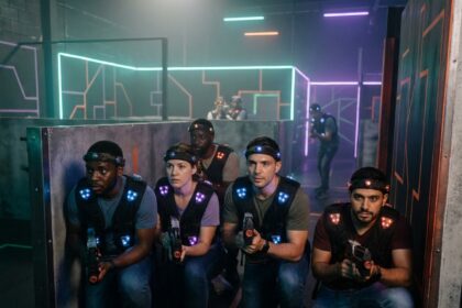 Équipe de collègues en pleine partie de laser game mobile à Lyon, portant des vestes tactiques dans une arène néon